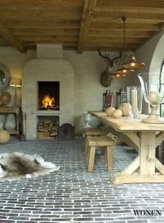 a living room filled with furniture and a fire place in the middle of an open floor plan