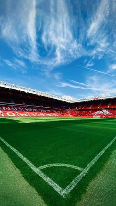 an empty soccer stadium with the sky in the background