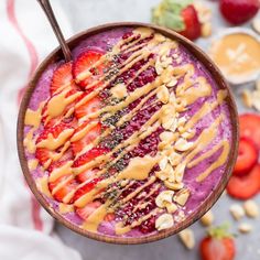 a smoothie bowl with strawberries, nuts and peanut butter on top is shown