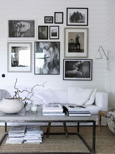 a living room with pictures on the wall and photos hanging above the couch in front of it