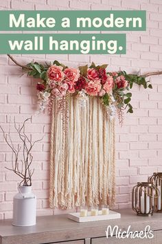 a pink brick wall with flowers hanging from it's side and candles on the table