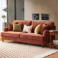 a living room filled with furniture and a rug on top of a hard wood floor