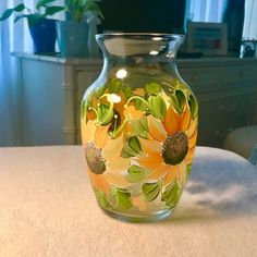 a glass vase with sunflowers painted on it