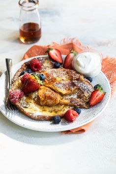 a white plate topped with french toast and berries