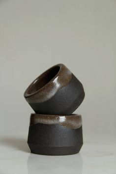 two black and brown vases stacked on top of each other