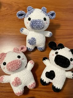 three crocheted stuffed animals sitting on top of a wooden table