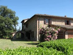 the house is surrounded by greenery and trees in front of it, as well as bushes