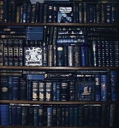 many books are stacked on top of each other in a bookcase, with one being read