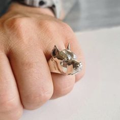 a person's hand with a ring on it that has two cats in the middle