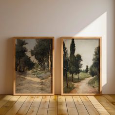 two paintings on the wall next to each other in an empty room with wood flooring