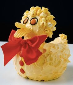 a cake shaped like a chicken with a red bow around its neck