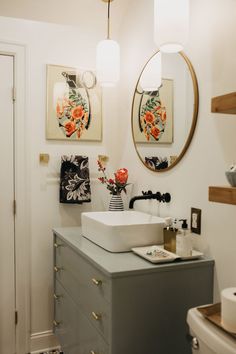 a bathroom with a sink, mirror and toilet in it's centerpieces