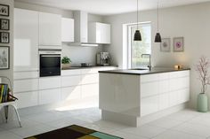 a modern kitchen with white cabinets and counter tops