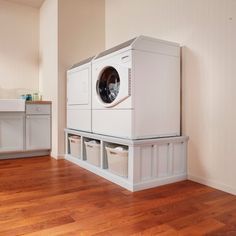 a washer and dryer sitting on top of a wooden floor in a room