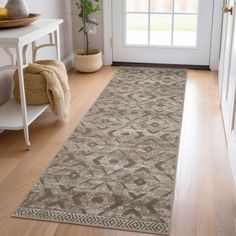 a large rug is on the floor in front of a door with a potted plant