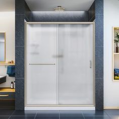 a bathroom with a walk in shower sitting next to a sink and a mirror on the wall