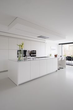 a large kitchen with white cabinets and counter tops