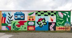 a large colorful mural on the side of a building in front of a parking lot