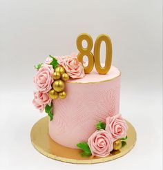 a pink and gold birthday cake with roses on it, the number 80 is decorated