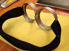 a pair of metal rings sitting on top of a table next to a laptop computer