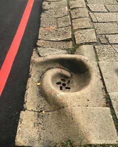 a drain hole on the side of a road