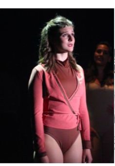 a woman in a red bodysuit standing on stage