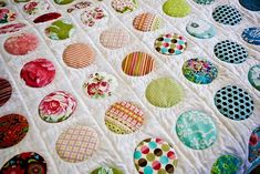 a quilted bed with many different colored circles on it