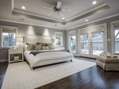 a large bed sitting in the middle of a bedroom next to a window with french doors