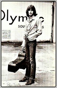 an old photo of a woman holding a guitar case