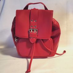 This Wild Fable Mini Flap Backpack is a stylish and practical addition to any outfit. The bag is made of high-quality faux leather, with a solid pattern and a vibrant red exterior color. It features a snap closure, convenient handle/strap, and measures 8.5 inches in width, 9 inches in height, and 4 inches in depth. The backpack is perfect for women who want to stay organized while on-the-go. Its spacious interior is lined with a gray color and can fit all your daily essentials. The backpack is a great choice for those who love the American theme and is made in Cambodia. Red Satchel Backpack, Everyday Red Faux Leather Satchel, Red Leather Flap Bag With Removable Pouch, Black Bookbag, Red Leather Backpack With Zipper Closure, Red Leather Backpack With Adjustable Strap For On-the-go, Herschel Backpack, Camo Backpack, Travel Laptop Backpack