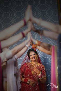 a woman standing in front of a mirror holding her hands up to the camera and smiling