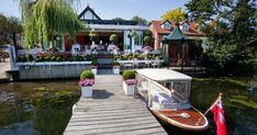 a boat docked at the end of a pier next to a house with flowers on it