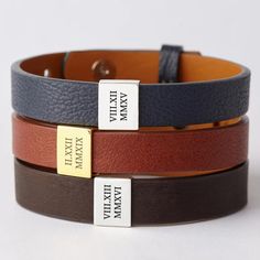 three different colored leather bracelets with name tags on each one and the other side