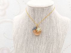 "A lovely and beautiful gold seashell locket necklace. It features a shining gold seashell along with mint green starfish and blue conch. It suspends in a gold finished brass chain along with lobster claw clasp closure. The shell locket inside can hold pictures in both side 16mm x 14mm. It is a wonderful idea for gift giving or as a little treat for yourself. Your necklace will present in a gift box and tied with ribbon. Measurements and details: Length: 16\", 18\", 20\", 22\", 24\", 26\" Locket Gold Shell Necklace With Starfish Charm As Gift, Gold Shell-shaped Necklace With Starfish Charm, Gold Necklace With Starfish Charm, Shell-shaped Charm Necklace As A Gift, Shell-shaped Charm Necklaces For Gift, Shell Charm Necklaces For Gift, Seashell Locket, Melody Mermaid, Shell Locket