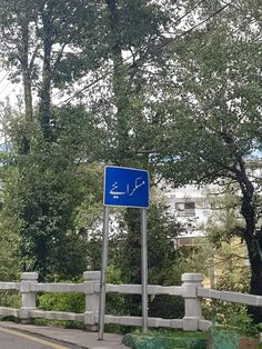 a blue street sign sitting on the side of a road