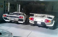 two white sports cars parked next to each other in front of an open garage door