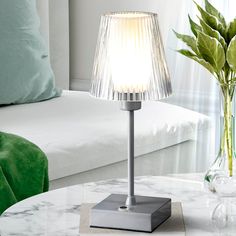 a white table lamp sitting on top of a glass table