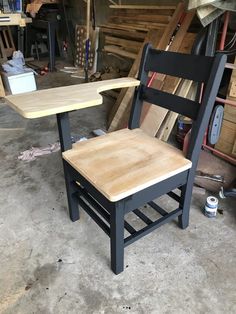 a wooden chair sitting next to a table on top of a hard wood floor in a garage