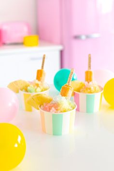 three cupcakes with popsicle sticks sticking out of them on a white table