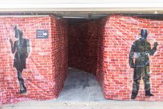 two red brick boxes are covered with plastic bags and one has a man in the middle