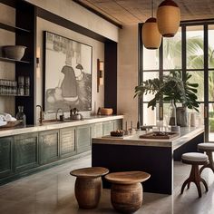 a kitchen with an island and stools in front of the counter top, surrounded by large windows