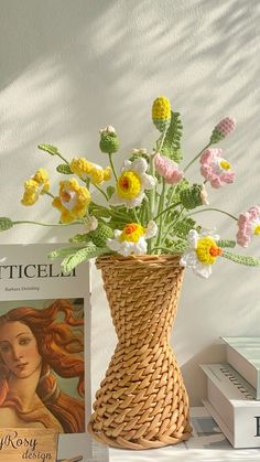 a vase filled with flowers sitting on top of a table next to books and magazines