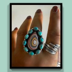 💙♥️This new Sterling Silver Turquoise Fordite Southwestern Statement Ring is ADJUSTABLE and super fun to wear! The colorful circles of the fordite are complemented by the surrounding turquoise clusters! It measures 1 3/4" long by 1 1/4" wide. Enhance your Southwestern lineup with this gorgeous cluster statement ring. Let us know what ring size you wear and we will adjust it to fit your finger size! ♥️💙 Reno Nv, Natural Turquoise, Artisan Craft, Silver Turquoise, Turquoise Sterling Silver, Rings Statement, Statement Ring, Reno, Circles