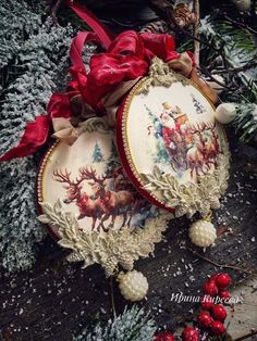 two christmas ornaments sitting on top of snow covered ground