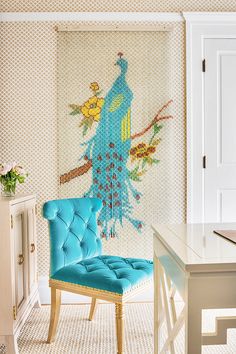 a blue chair sitting in front of a wall hanging on the side of a door