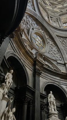 the interior of a church with statues and a clock on it's side wall