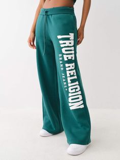 Experience comfort and style with the Puff Print Logo Sweat Pant. Crafted from fleece lining, this pair of sweats features a drawstring high-rise waist, slanted front pockets, and a wide leg. Finished with a front True Religion arched puff print logo. 60% COTTON / 40% POLYESTER Cool Bottoms For Women, Low Rise Sweatpants 2000s, Sweatpants With Words On Back, Women Wishlist, Winter Chill Outfits, Cute Online Clothing Stores, Cute Sweats, Cheap Clothing Websites, Leg Model