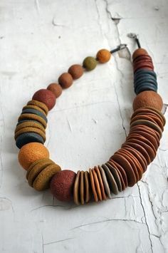 a multicolored necklace is displayed on a white surface