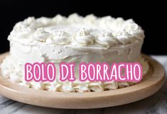 a white cake sitting on top of a wooden plate with the words bolo di borracho