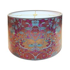 an orange and pink lamp shade with floral designs on the bottom, gold trimming